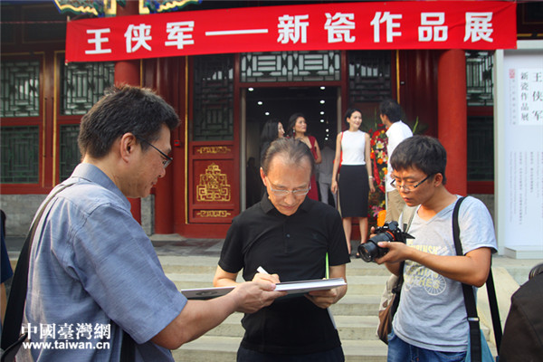台湾艺术家王侠军（左二）为观众签名。（中国台湾网 郜利敏 摄）